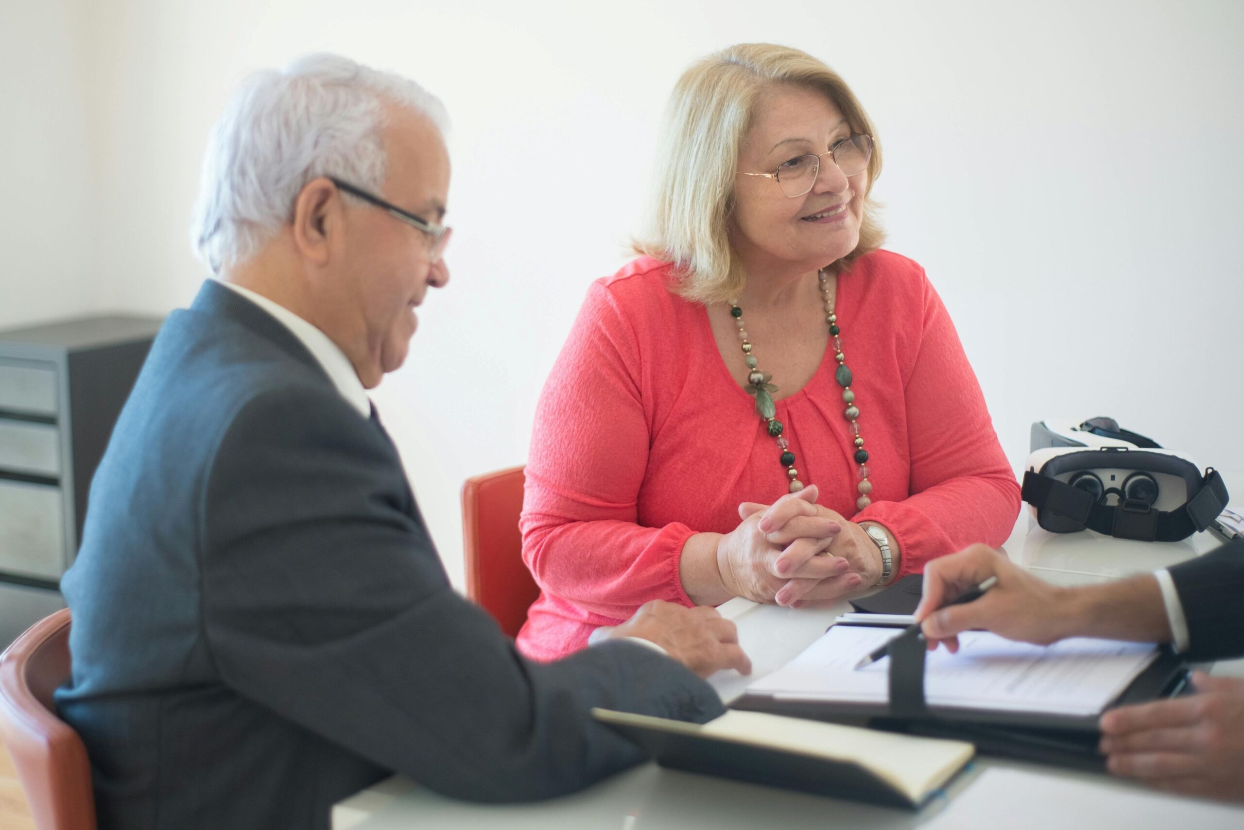 elderly couple in conversation: Melbourne brokers help seniors with reverse mortgages application.