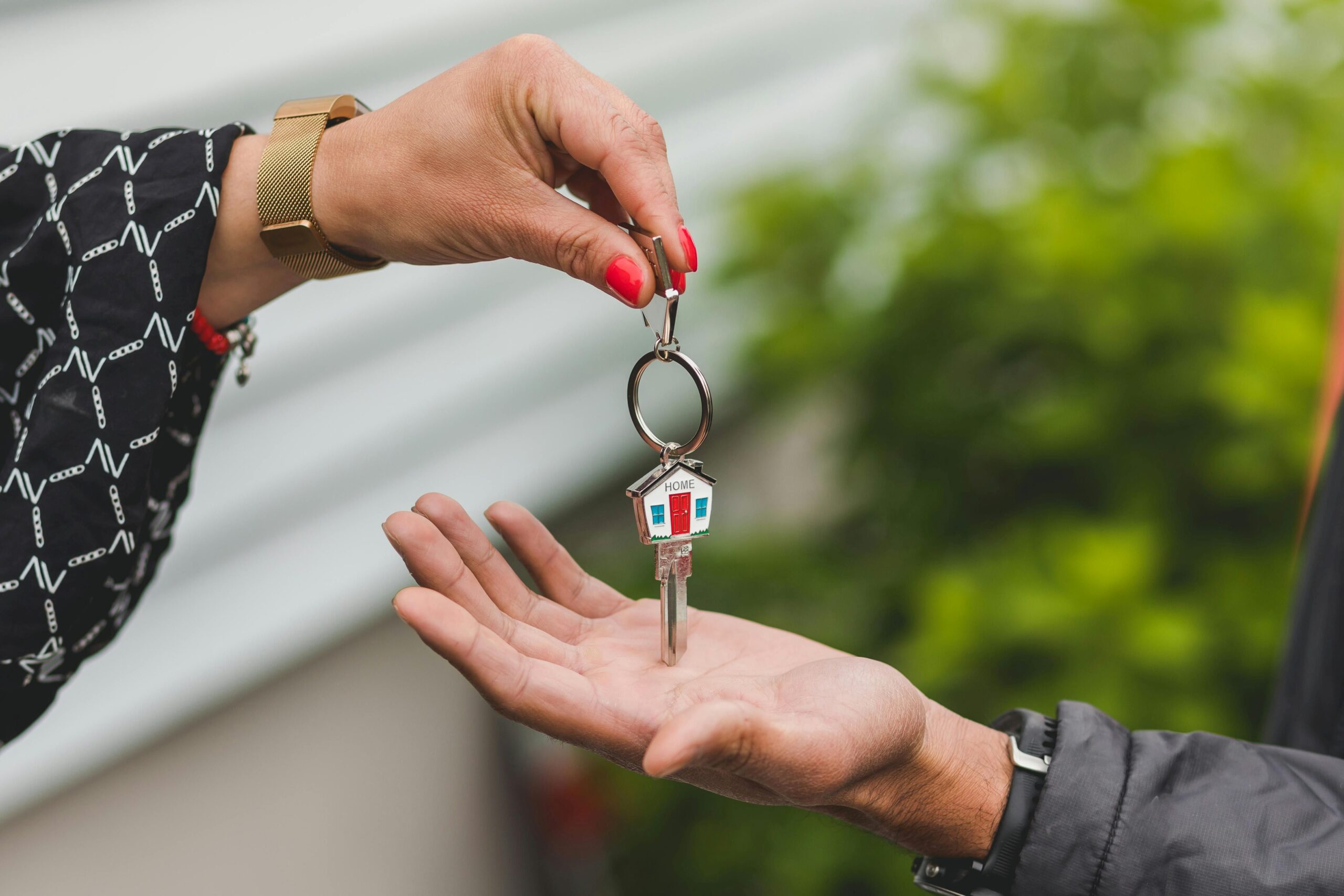 A hand giving a key to another hand.