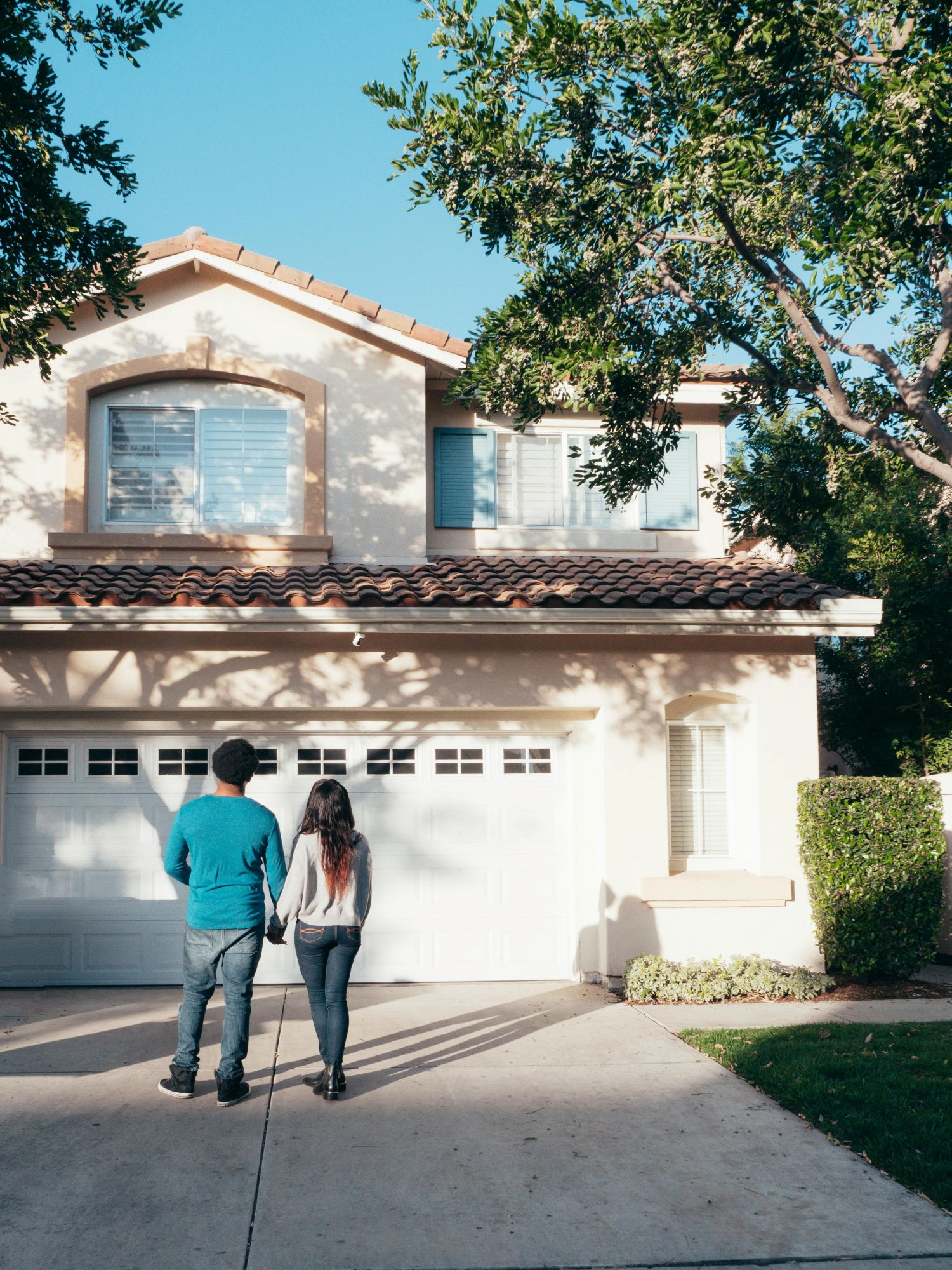 A couple standing outside of house.