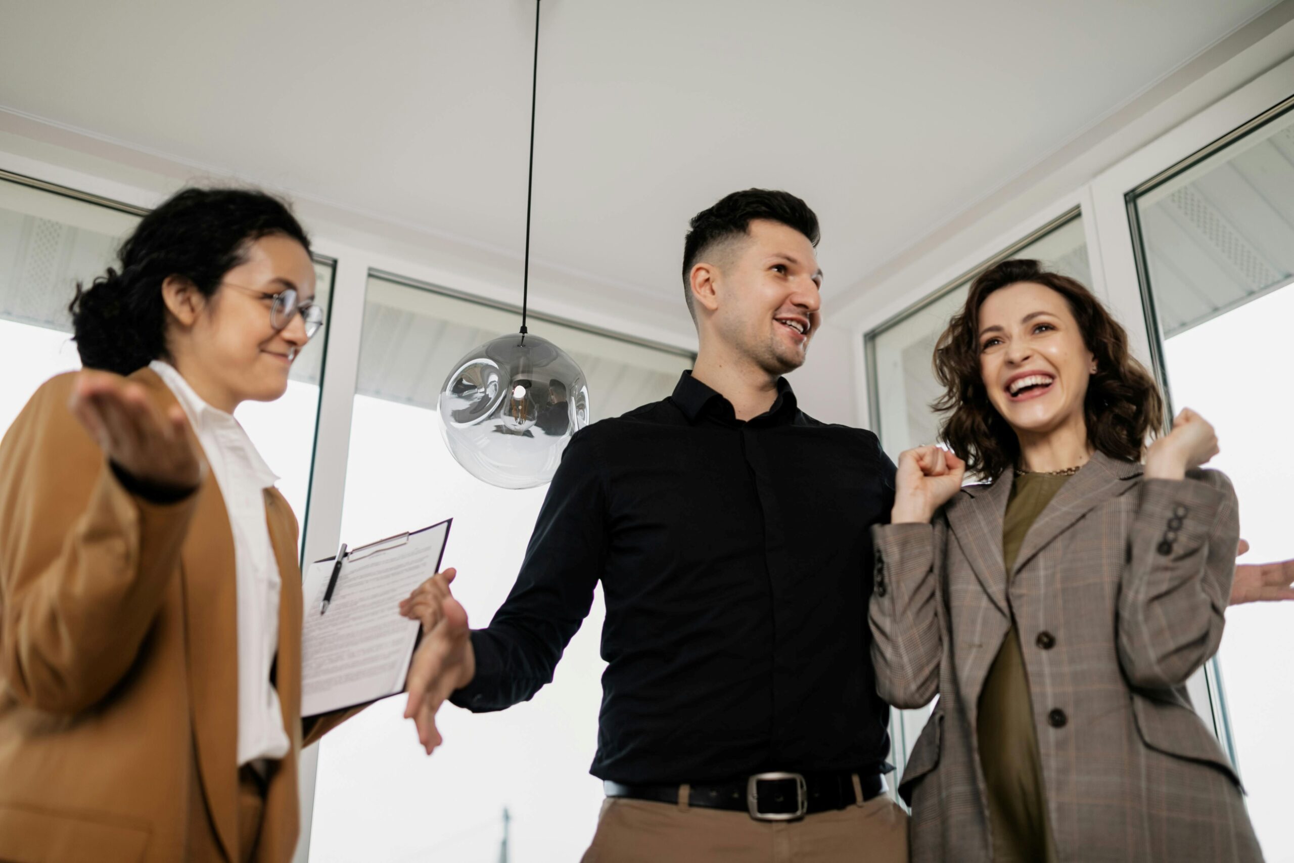 A happy couple in discussion with female agent.