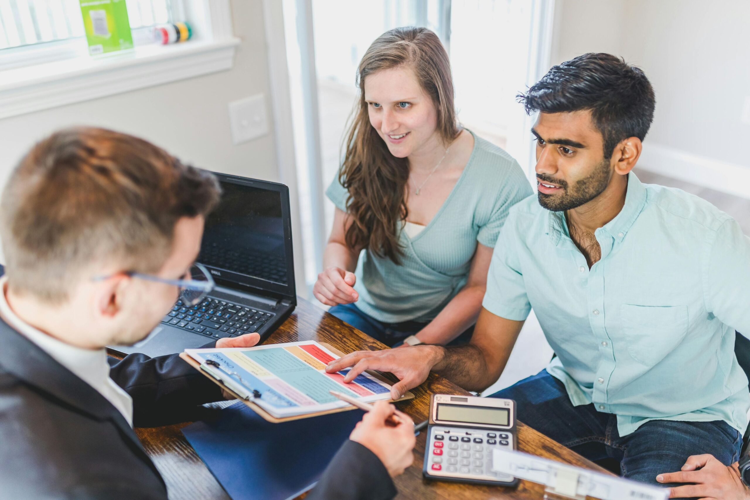 A couple discussing with a male broker agent.