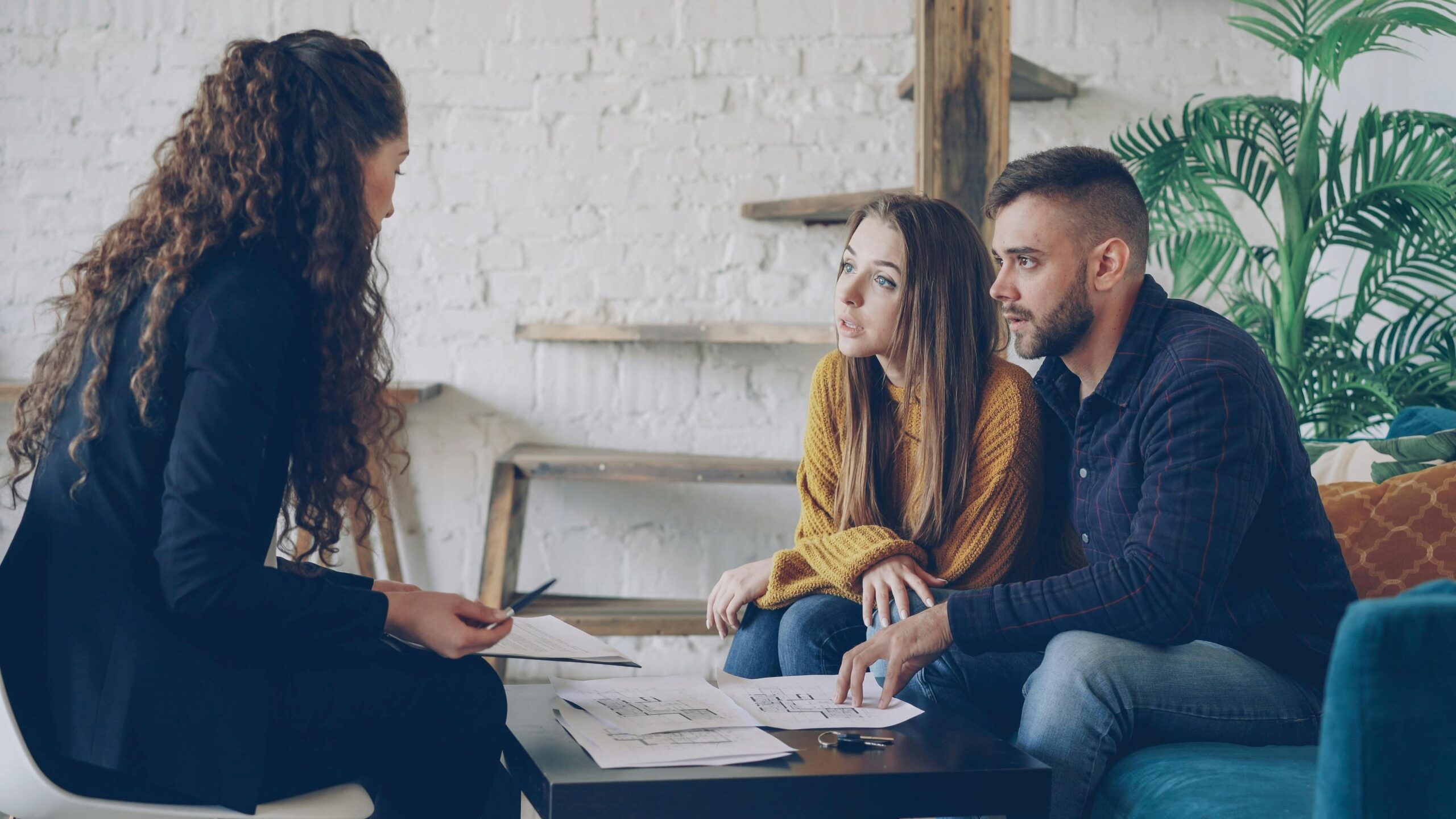 A couple discussing with a female agent.