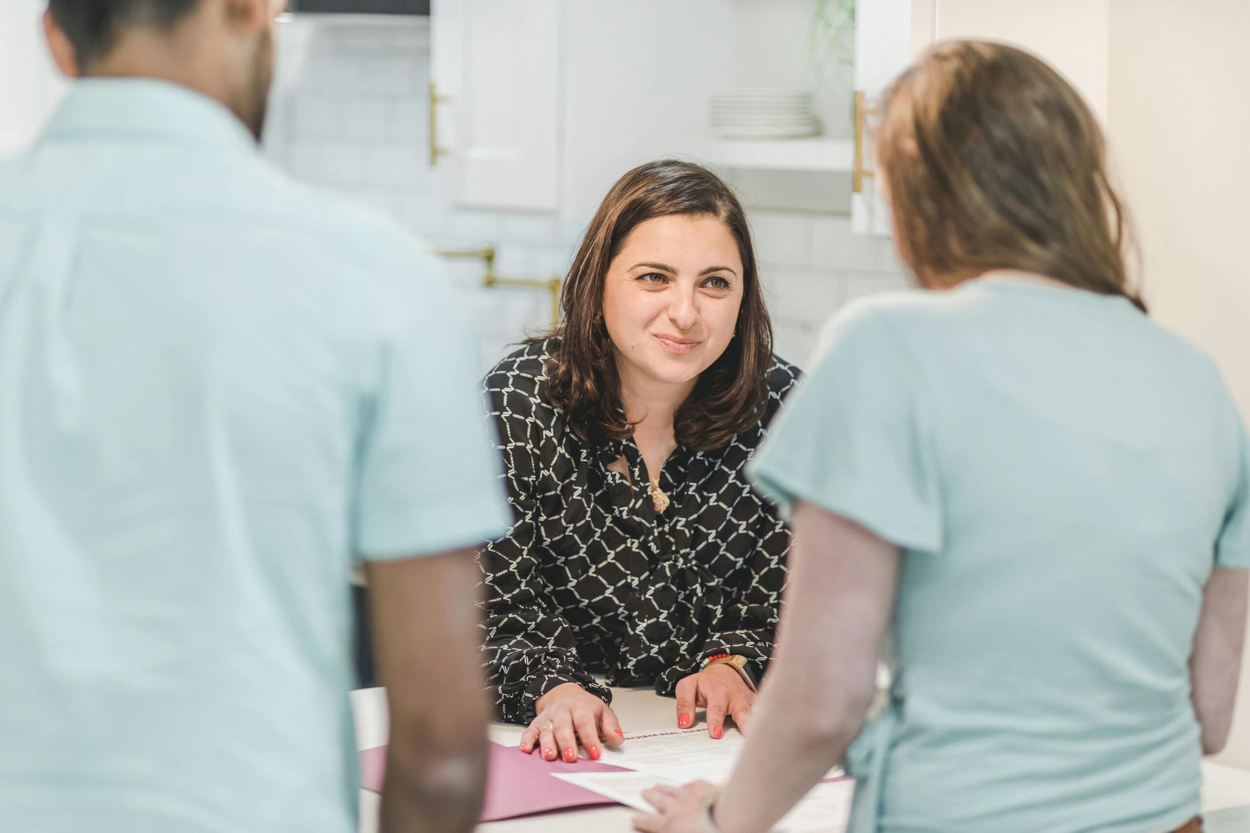 A couple engaged in a discussion with female agent.