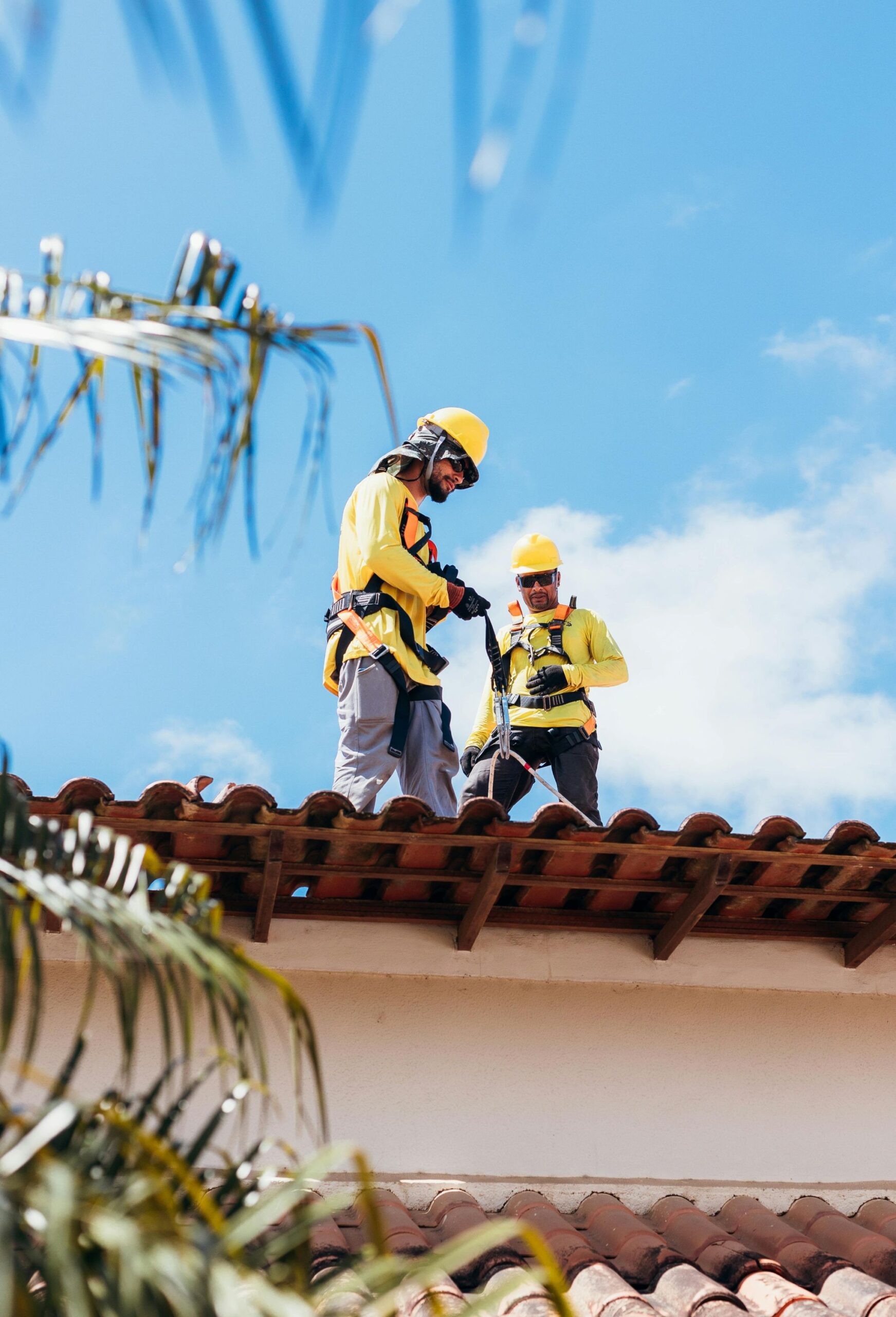 Roofers working on top of house.