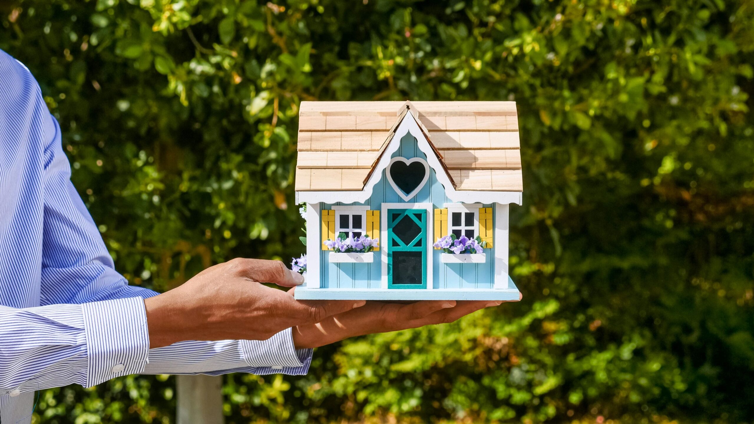 A hand holding a house model.